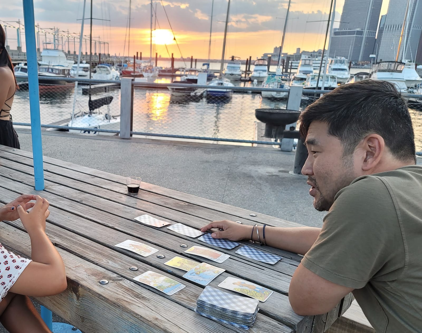 Jimmy giving a tarot reading at a marina at sunset